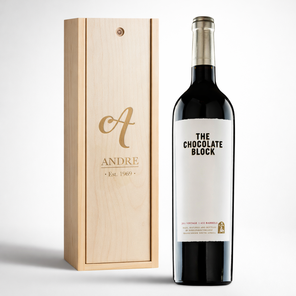 Wine bottle with 'The Chocolate Block' label next to a wooden box with custom laser engraving on it.