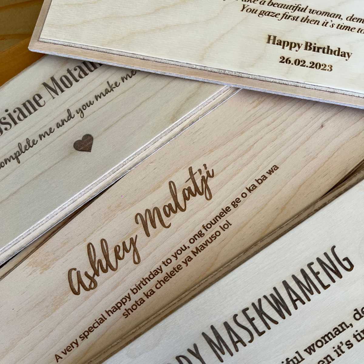 Wooden wine box lids with engraved names and messages on.