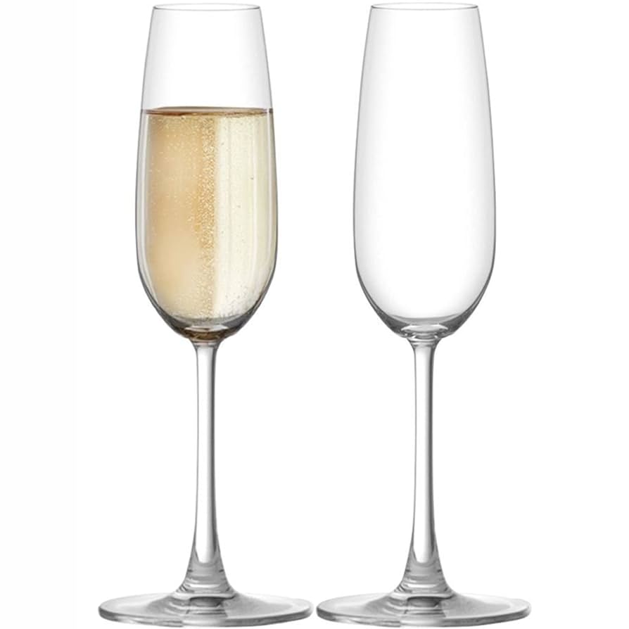Two champagne flutes, one filled with champagne, on a white background