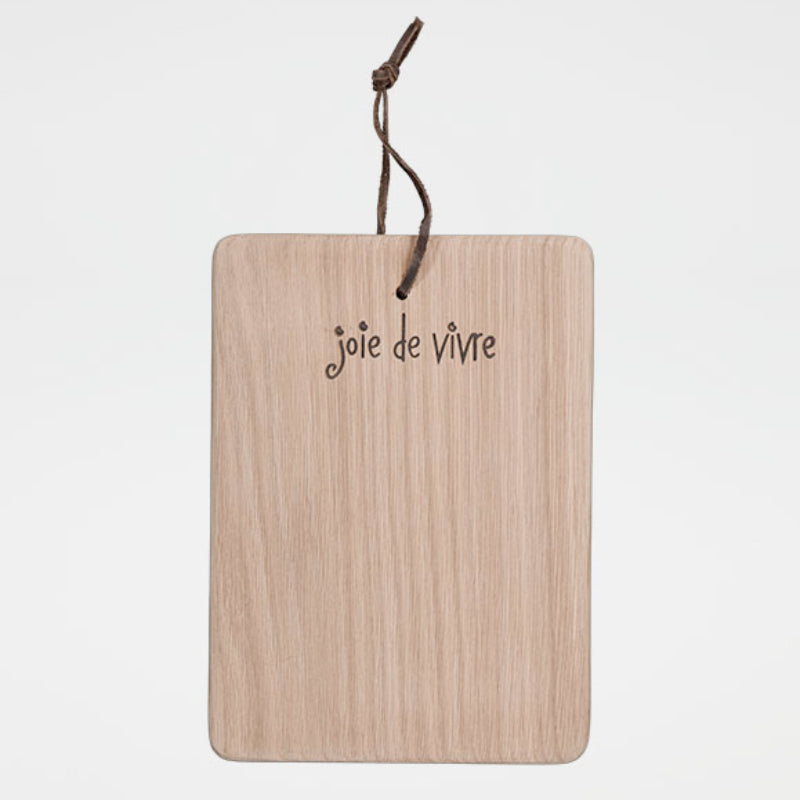 Wooden cutting board with 'joie de vivre' text and string on a white background