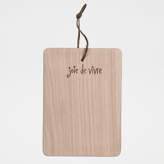 Wooden cutting board with 'joie de vivre' text and string on a white background