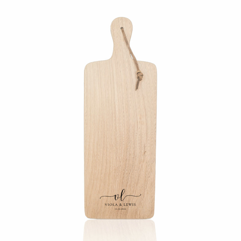 Wooden cutting board with a handle and engraved logo on a white background