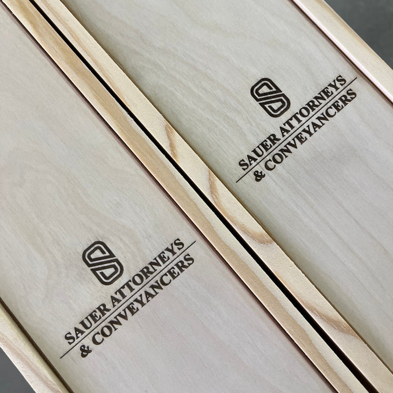 Wooden box with 'Sauer Attorneys & Conveyancers' branding on a gray background