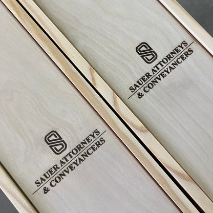 Wooden box with 'Sauer Attorneys & Conveyancers' branding on a gray background