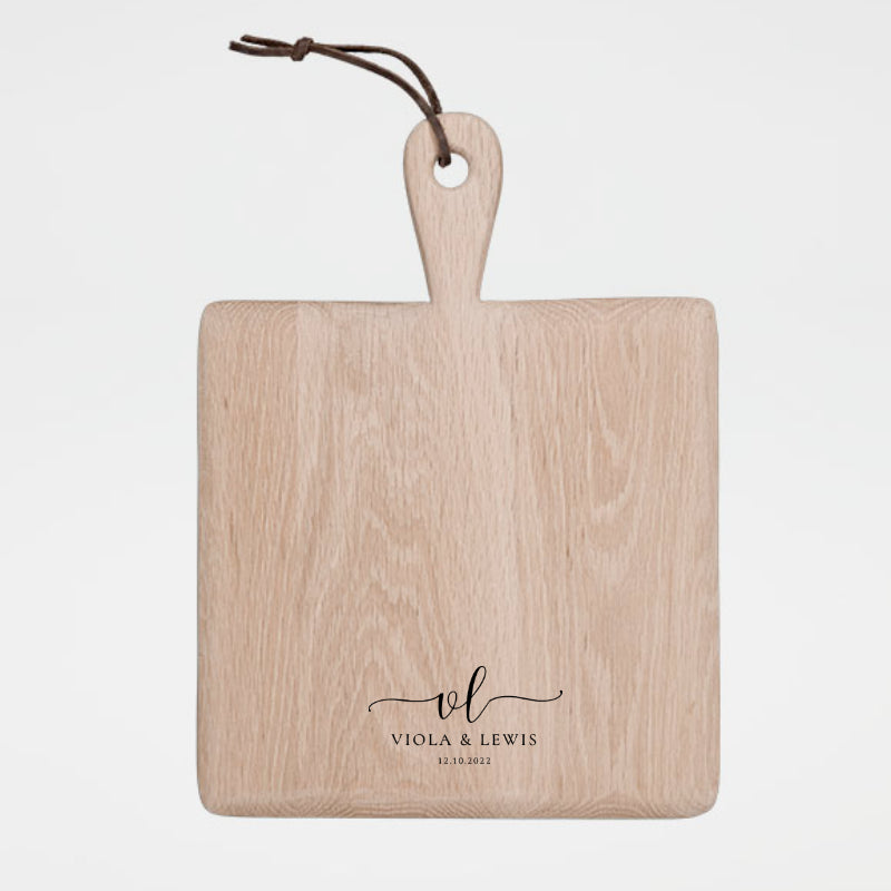 Wooden cutting board with a handle and engraved text on a white background
