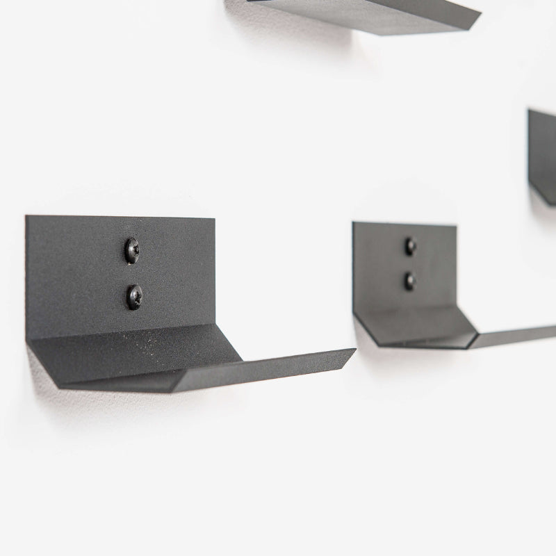 Two black metal wine holder brackets on a white background